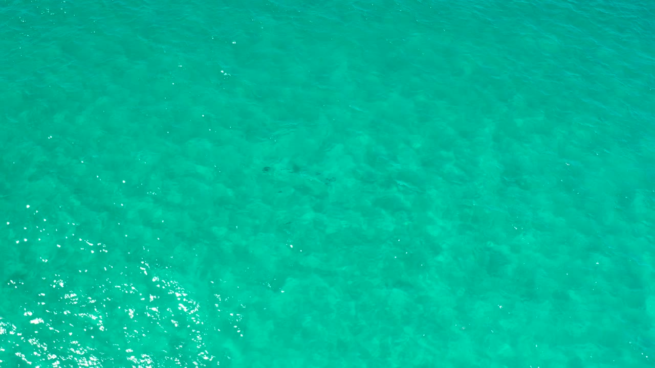 Clear blue-green ocean water in Los Cabos, Mexico, fills the frame with subtle wave ripples and no visible people.