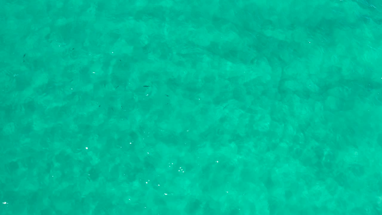 Aerial ocean water with darker patches below