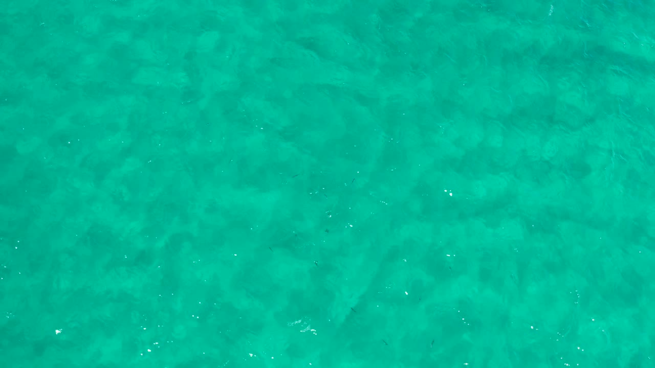 Turquoise sea surface in Los Cabos, Mexico, with a slightly denser band of white sparkle and no visible people, shoreline, or structures.