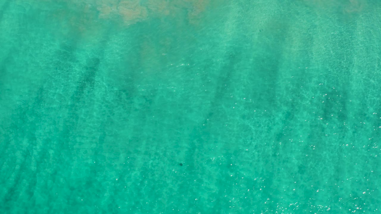 Turquoise shallow ocean over a sandy bottom