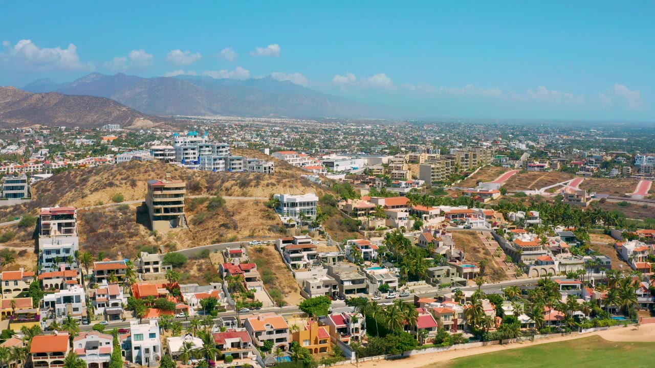 Aerial neighborhood view with a prominent dry hill and homes below.