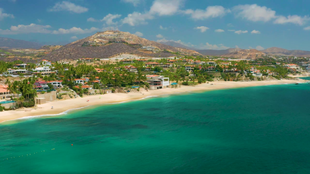Beachfront neighborhood seen from above with calm water and mountain beyond
