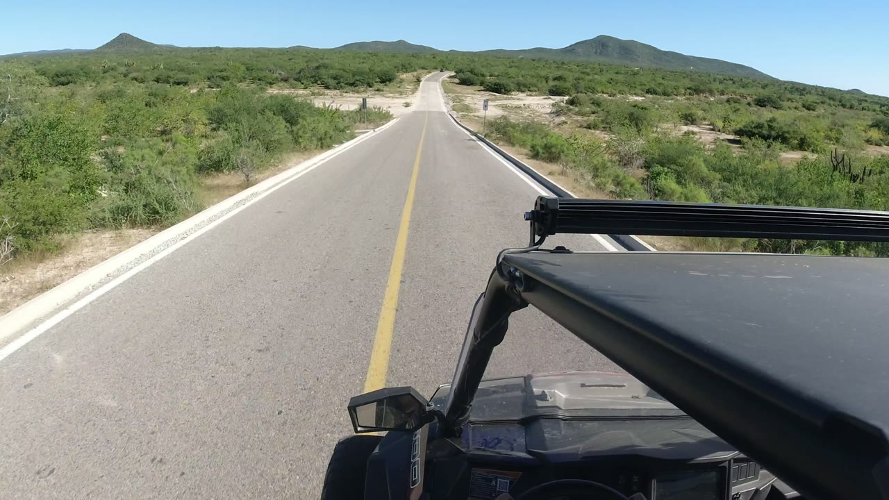 Forward view from an SUV on a paved desert road