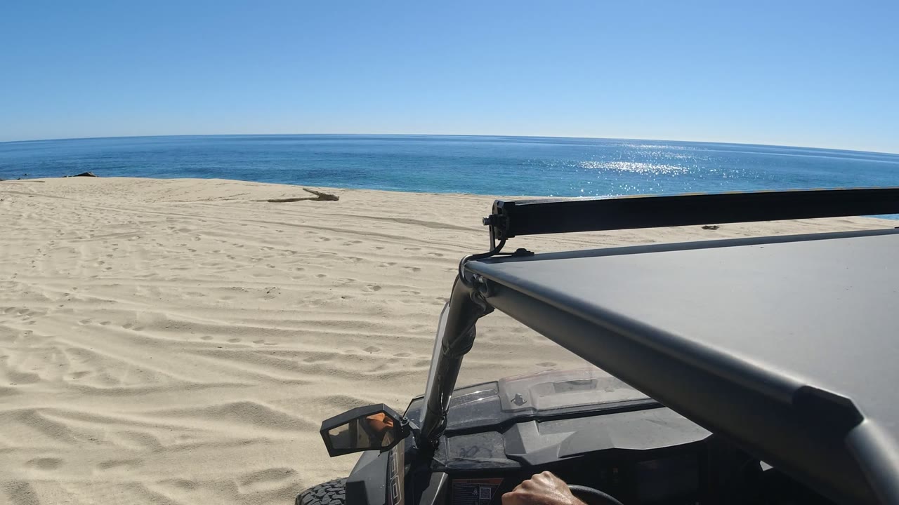 Off-road vehicle hood on sand dunes beside the ocean.