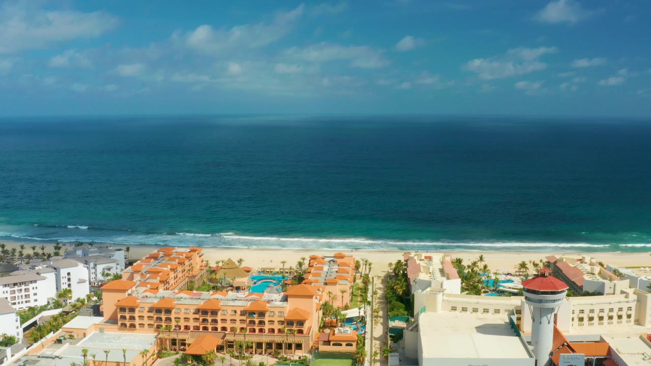 Aerial view of resort buildings beside blue ocean and sandy beach