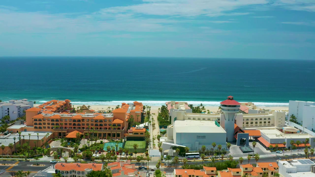 Aerial view of ocean, beach, and resort buildings.