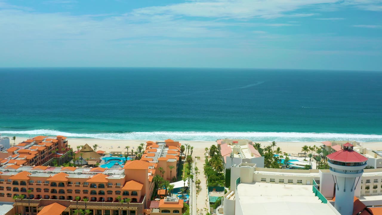 Wide aerial resort coastline with surf and blue water