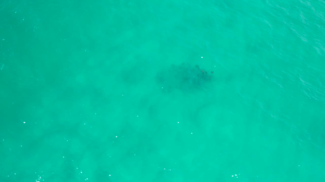Transparent turquoise sea in San Jose Del Cabo, Mexico, with a darker submerged patch near the upper frame and no visible people.
