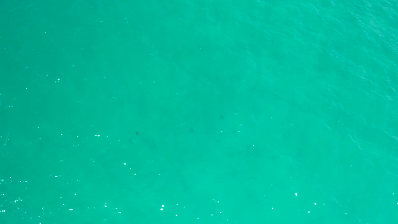 Straight-down view of turquoise sea in San Jose del Cabo, Mexico, showing soft wave texture and no visible people, boats, or buildings.