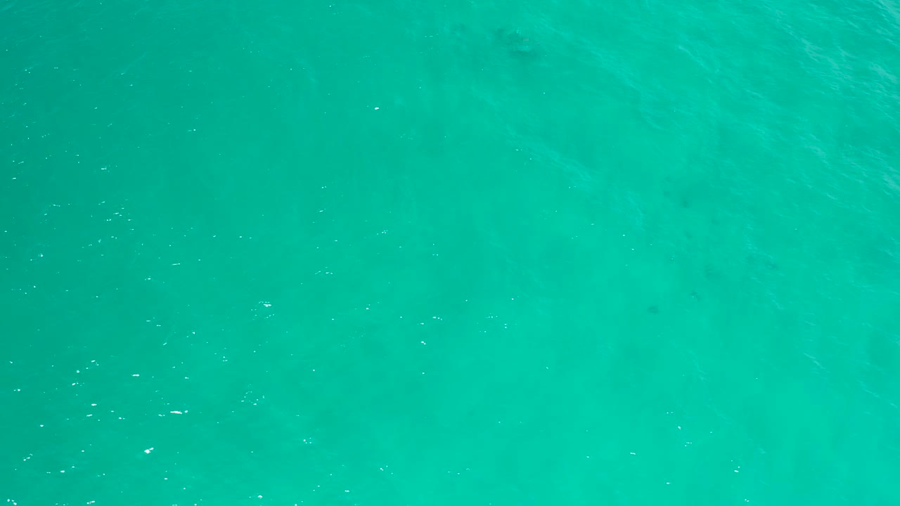 Bright turquoise ocean water in San Jose Del Cabo fills the frame with a lightly rippled surface and no visible people.