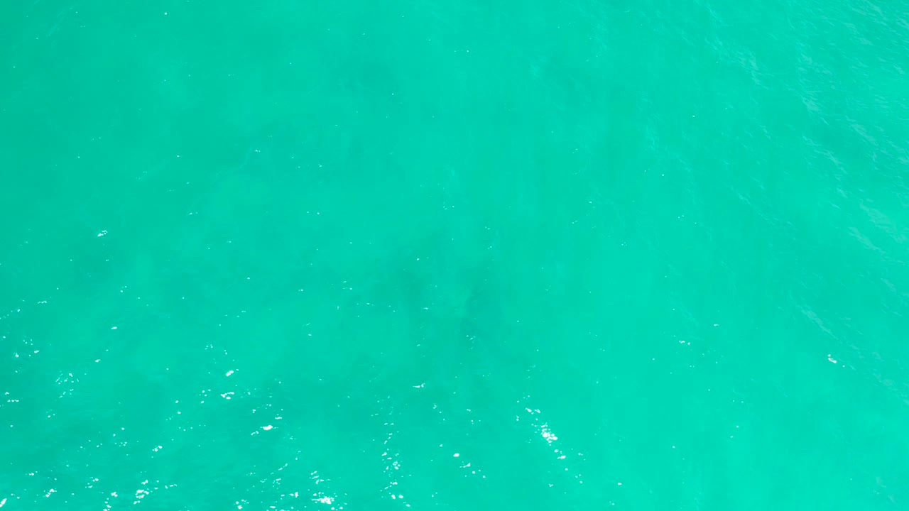 Aerial top-down frame of San Jose Del Cabo sea water, with brighter ripple marks across the center and no visible people or vessels.