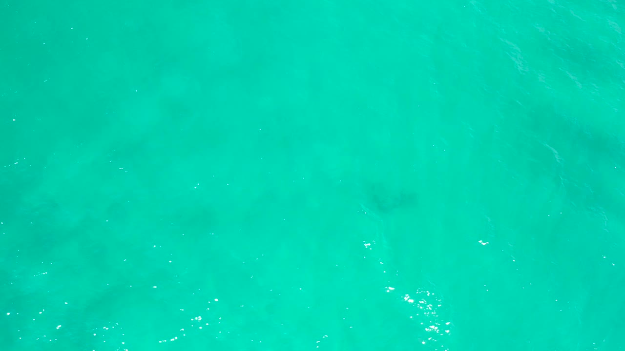 Blue-green ocean surface in San Jose Del Cabo, Mexico, with scattered white light reflections and no visible people.