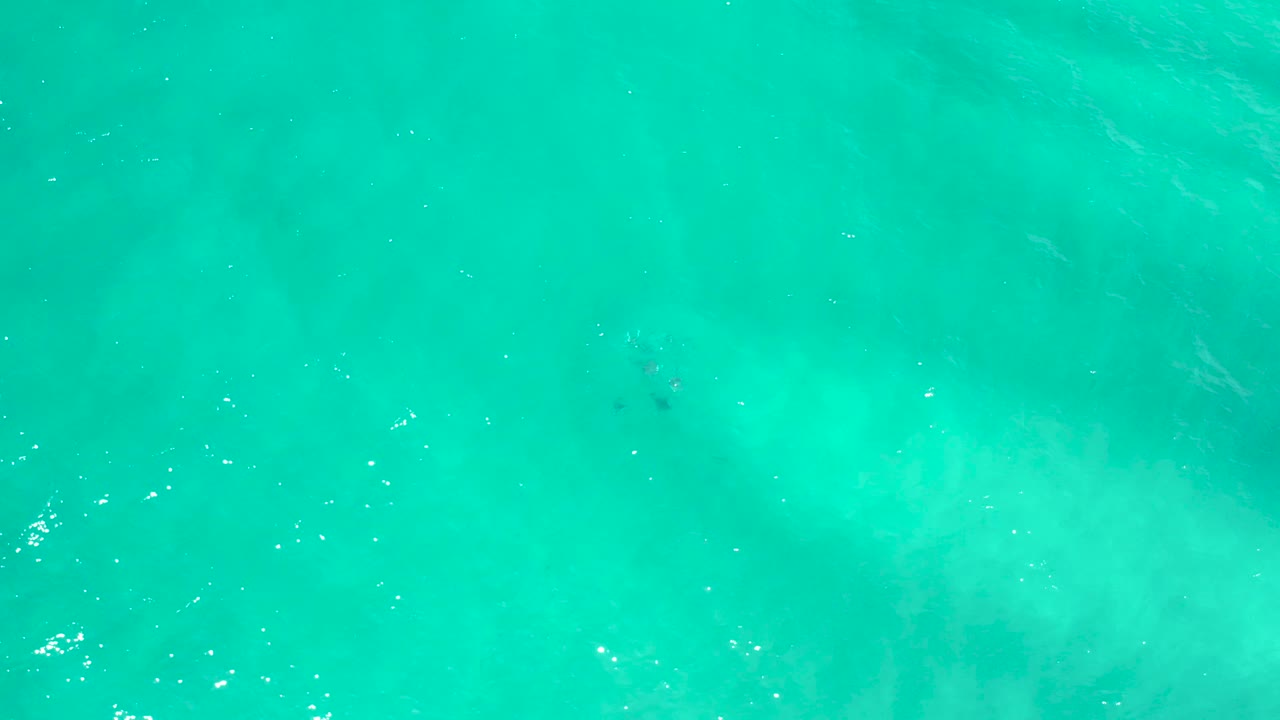 Turquoise water in San Jose Del Cabo, Mexico, with faint diagonal wave lines, muted submerged shading, and no visible people.