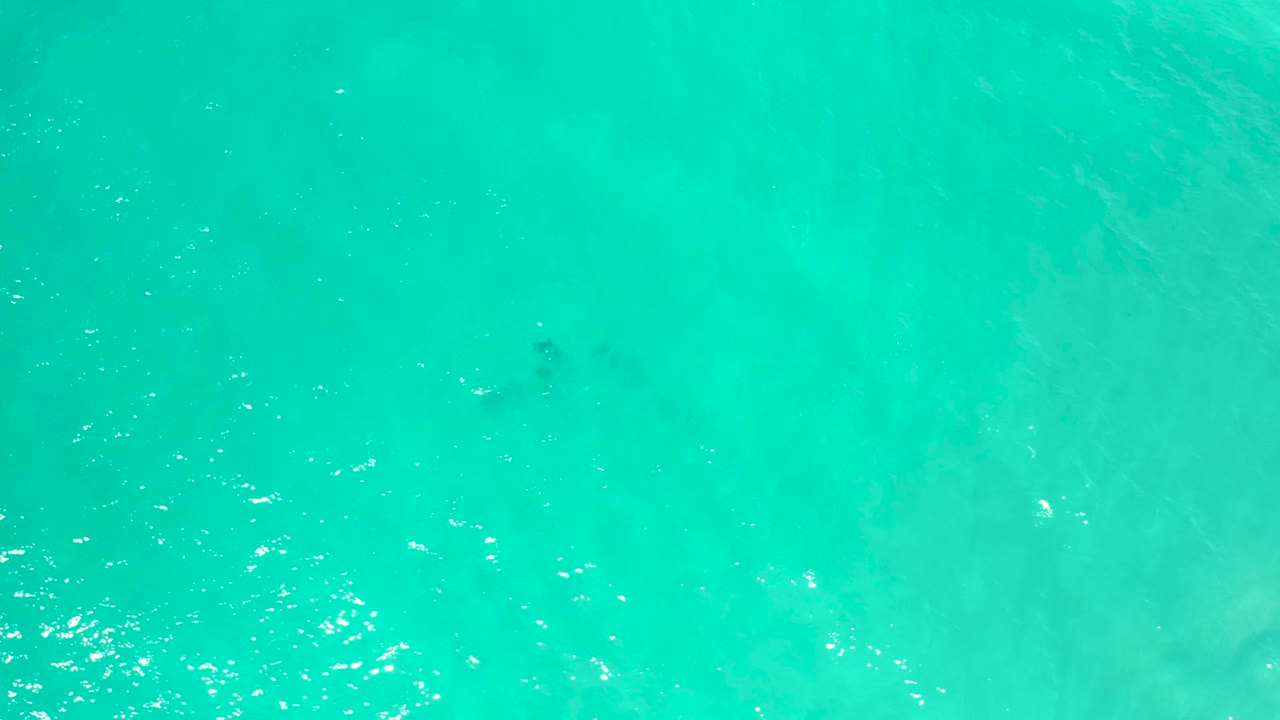 Clear blue-green water with pale underwater patches