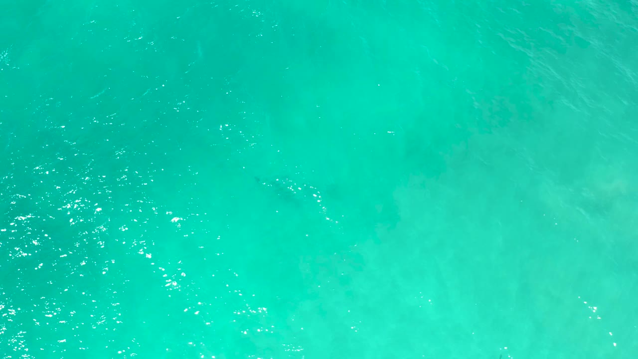 Clear blue ocean water in San Jose Del Cabo, Mexico, seen from above with pale cloudy patterns under the surface and no visible people.