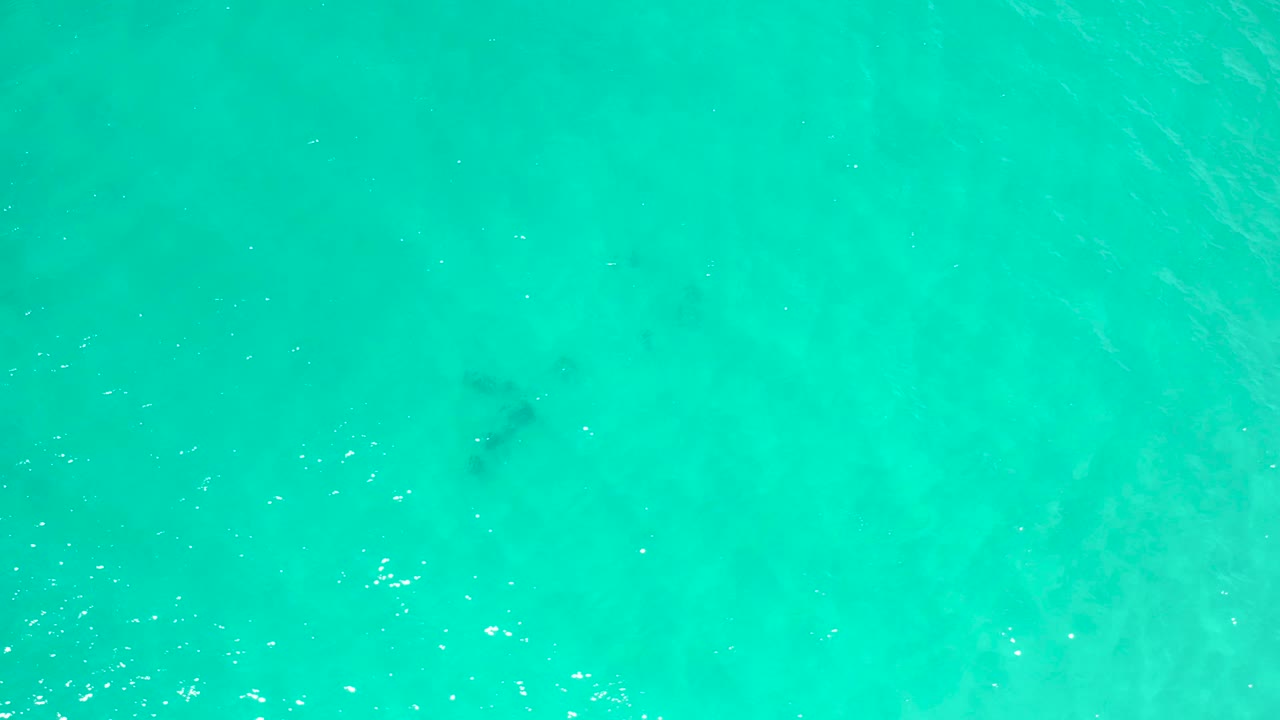 Bright aqua water in San Jose Del Cabo, Mexico, with soft darker underwater patches near the center and no visible people.