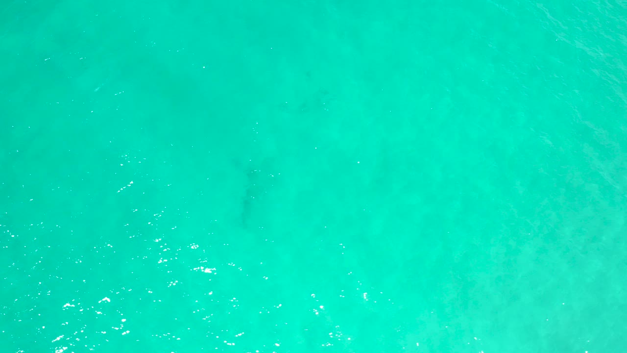 Overhead view of turquoise ocean water in San Jose Del Cabo, Mexico, with faint underwater patches and no visible people.