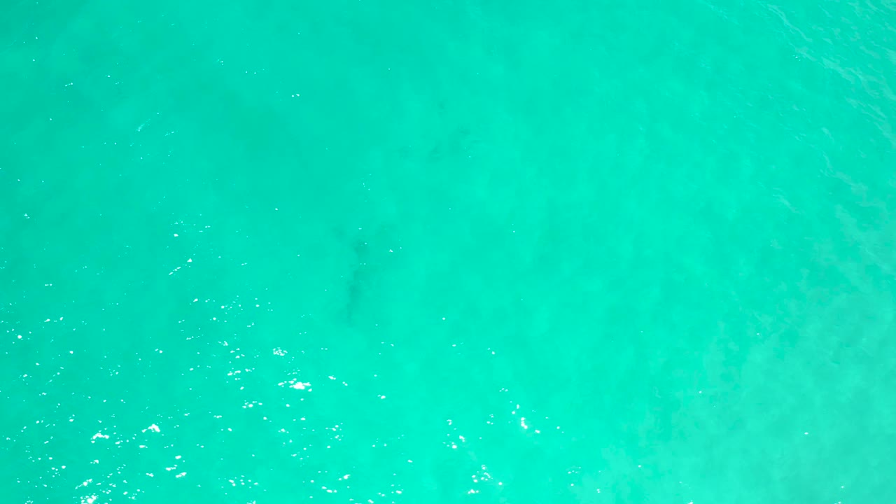 Clear blue-green ocean surface in San Jose Del Cabo, Mexico, with small white highlights across the water and no visible people.