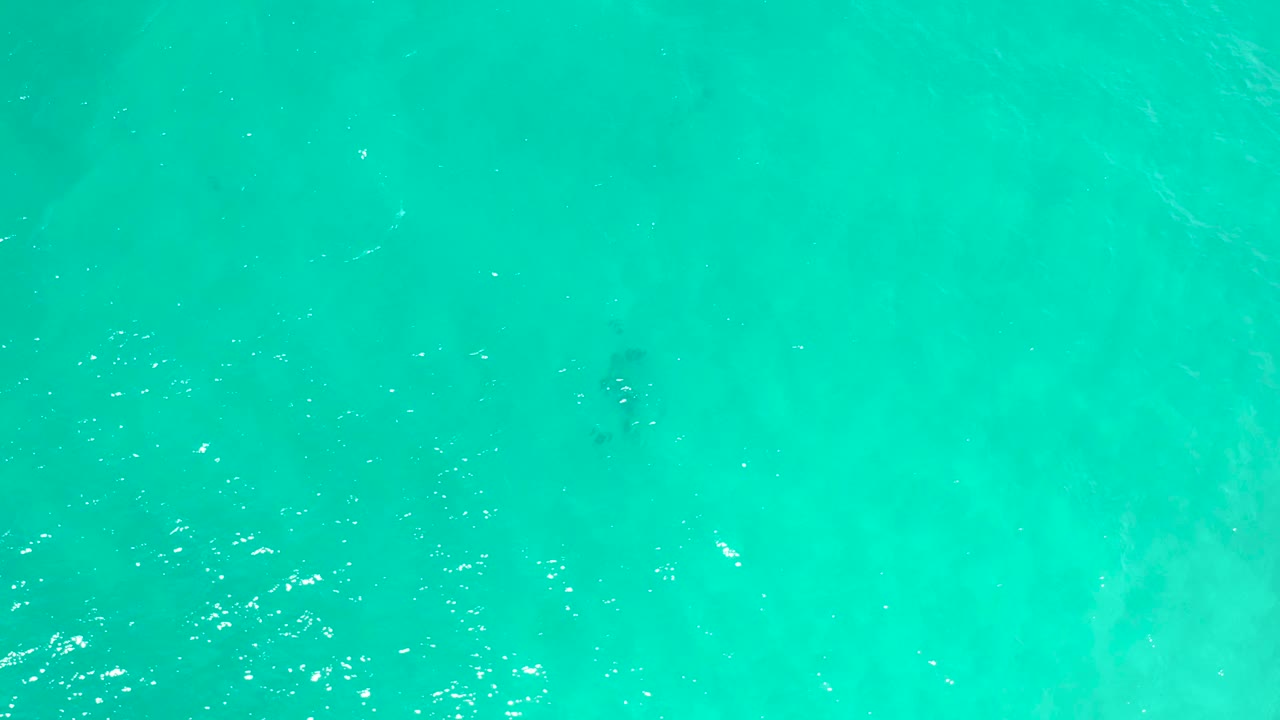 Blue-green ocean water fills the frame in San Jose Del Cabo, Mexico, with rippled highlights and faint darker areas under the surface, no visible people.