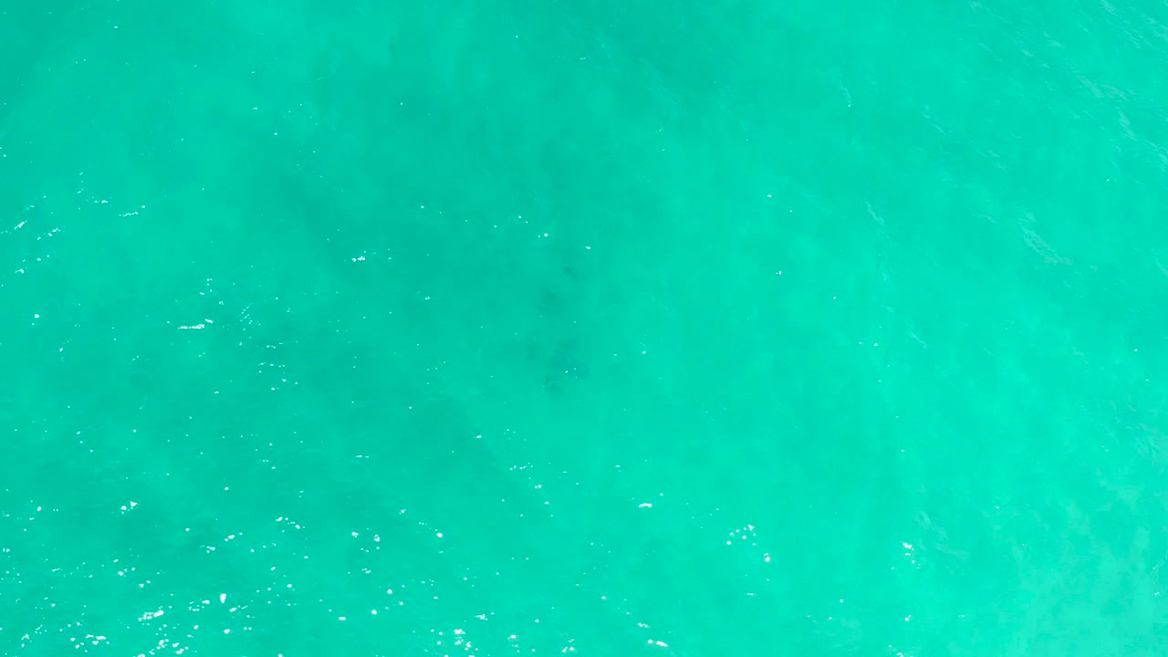 Bright aqua sea surface in San Jose Del Cabo, Mexico, seen straight down with small ripples and no boats or visible people.