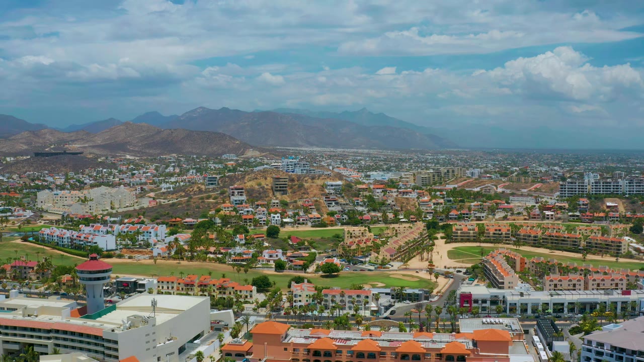 Aerial view of city blocks below a mountain range