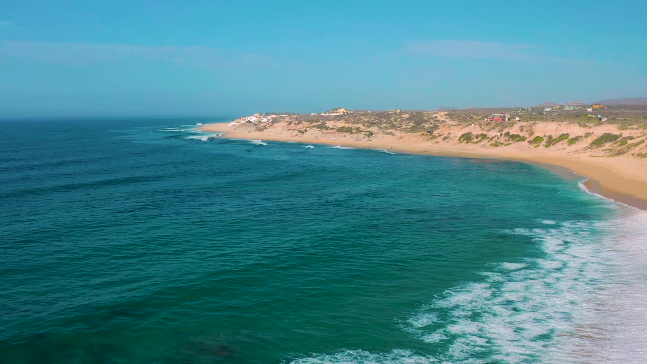 Wide beach coastline with surf breaking along the right side.