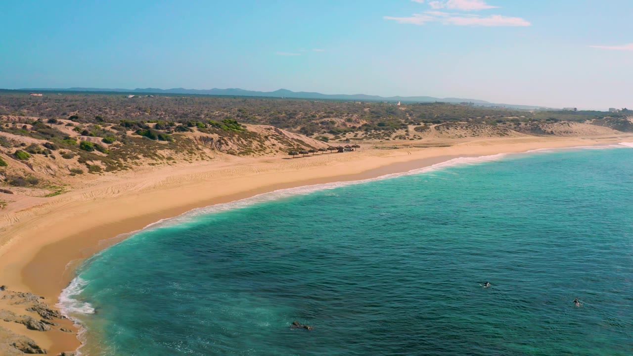 Aerial shoreline with empty sand, rocks, and clear water