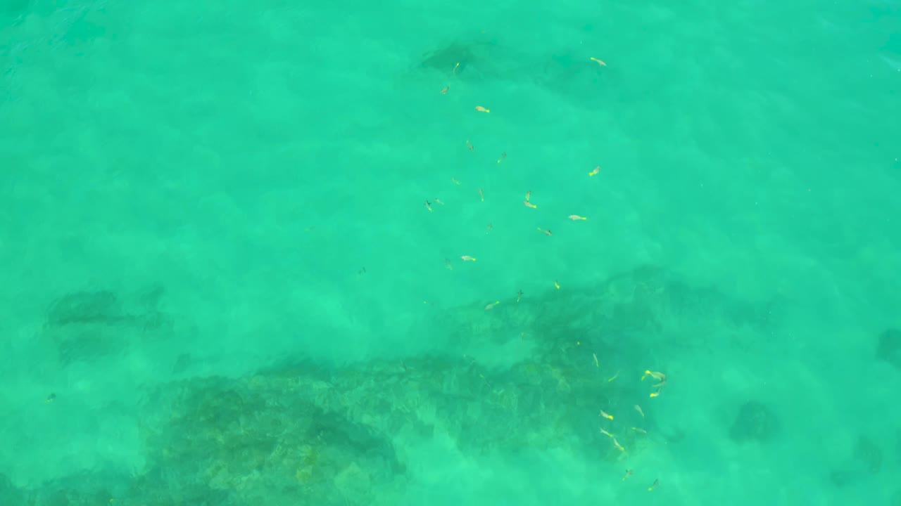 Aerial-looking water texture at Shipwrecks Beach, Baja California Sur, showing turquoise surface color, muted seafloor detail, and no visible people.