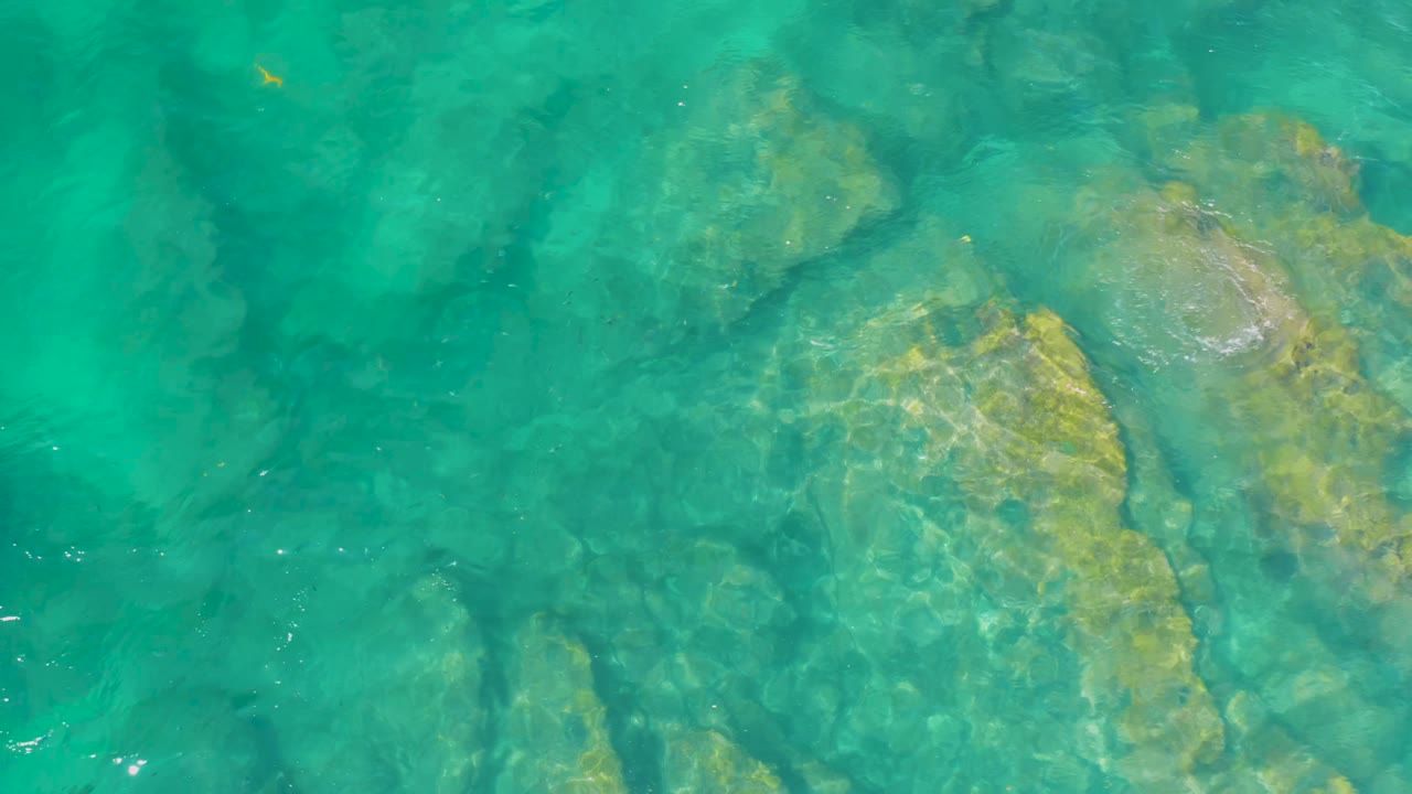 Clear ocean water with rock shapes beneath the surface
