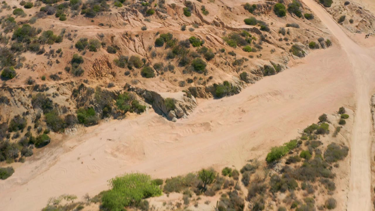 Aerial desert terrain with sand wash and green shrubs