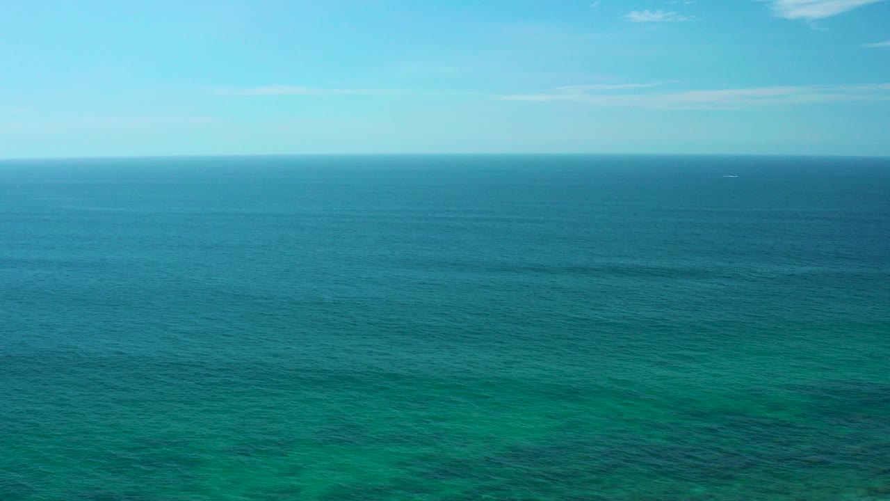 Wide aerial view of turquoise ocean at Shipwrecks Beach, Baja California Sur, with a level horizon and no visible people.