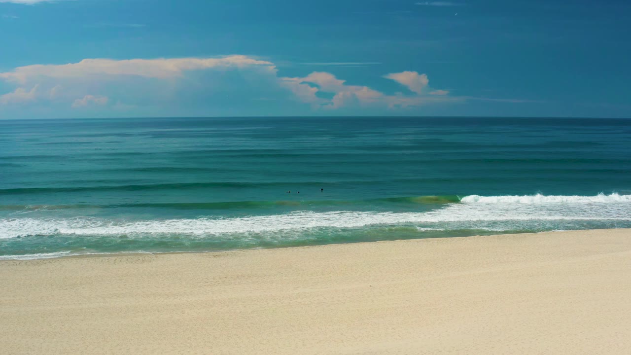 Ocean horizon and sandy beach with a bright surf line.