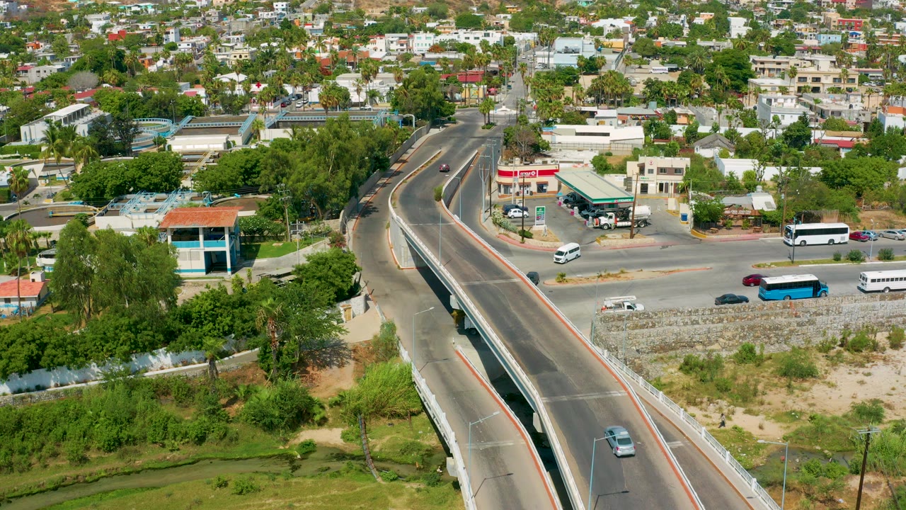 Elevated view of cars and buses near an overpass and city blocks.