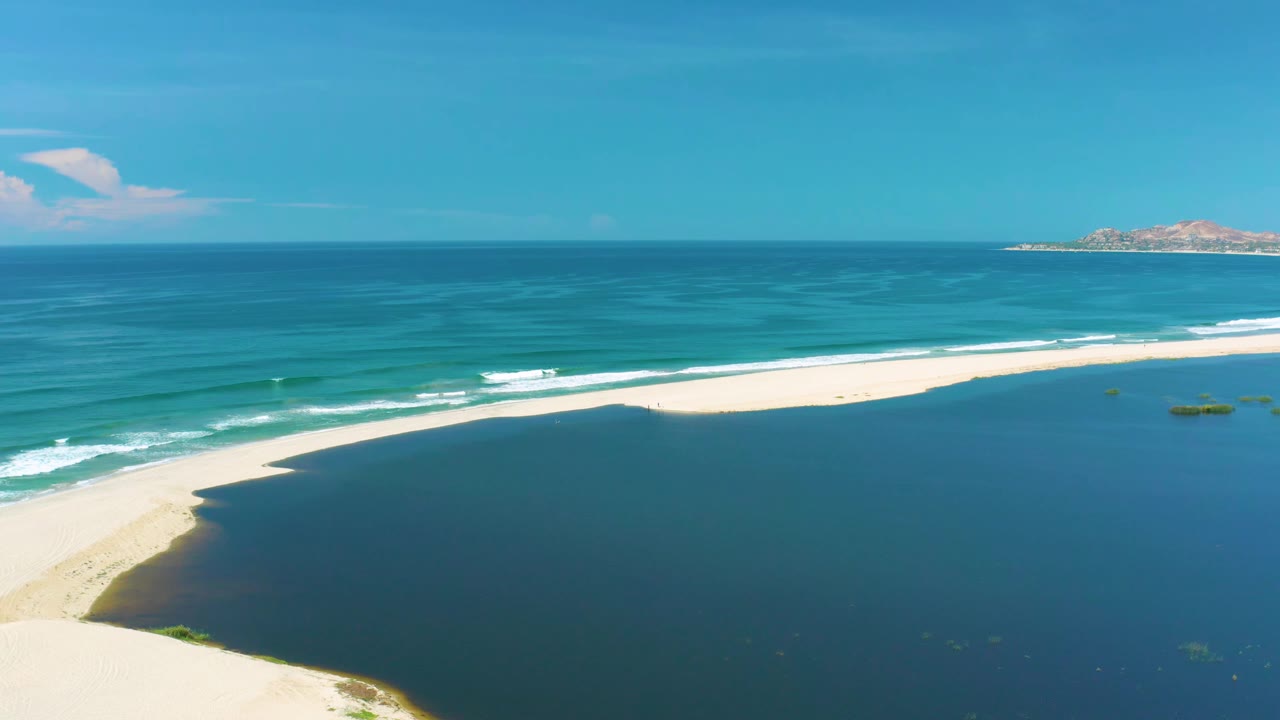 Wide coastline view with surf bands crossing a long sand beach.