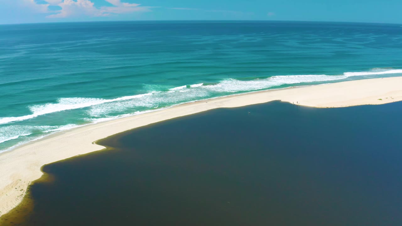 San Jose Del Cabo aerial view with the wave line slightly farther across the beach edge, dark water filling the lower frame, and no visible people.