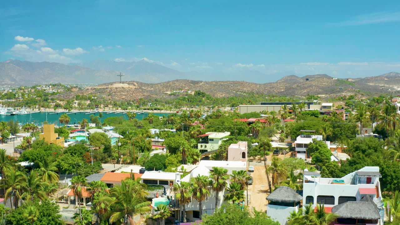 Sunlit villas and palms beside a blue marina basin