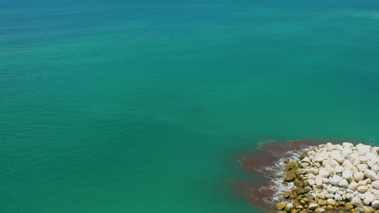 Wide turquoise water with rocks at bottom right
