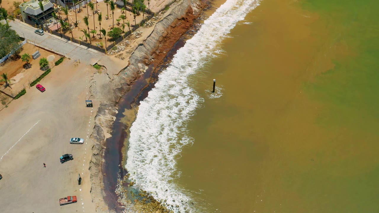 Drone view of surf crossing a discolored shoreline