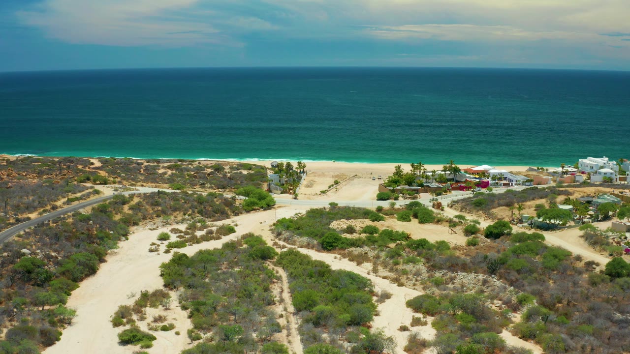 Third frame shows the San Jose Del Cabo shoreline from above, with ocean filling the upper half, sandy vegetation below, and a cluster of small buildings near the right beach access, with no visible people.