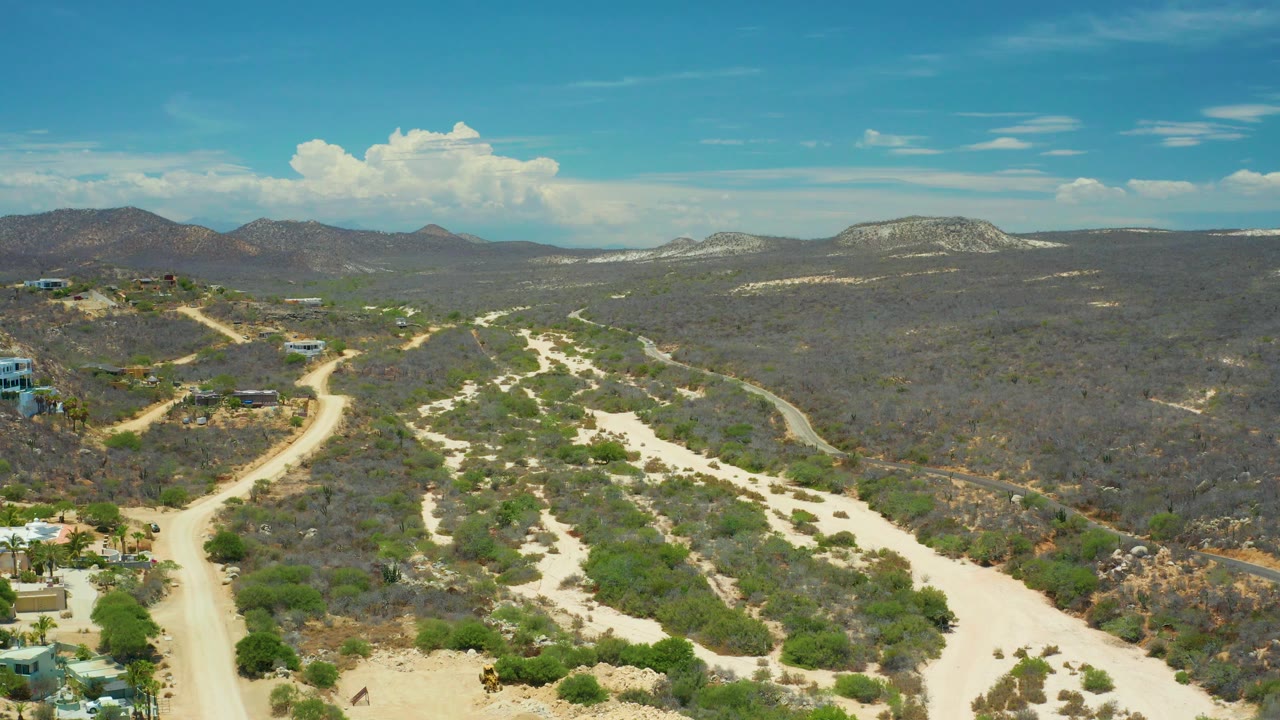 Wide aerial view of dirt tracks and dry vegetation