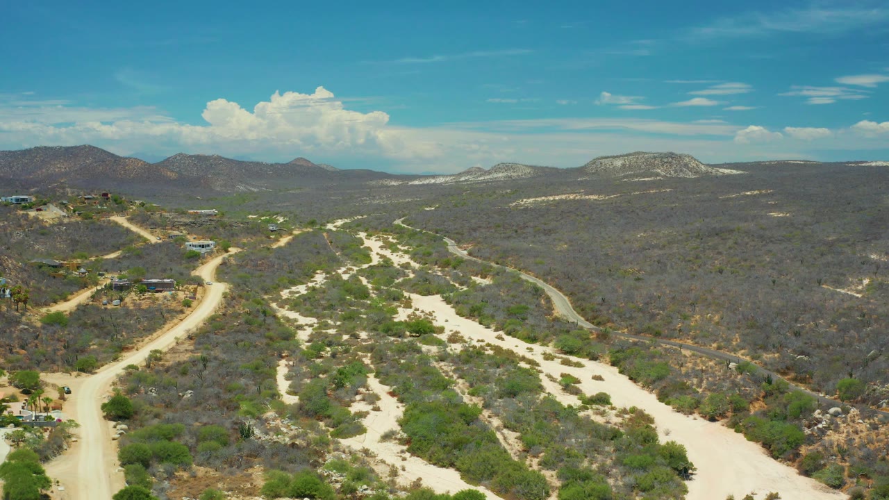 Aerial view of winding trails beside dry brush and low mountains