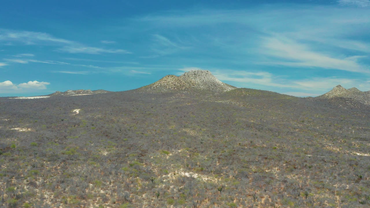 Scrubland and rocky mountains under a blue sky