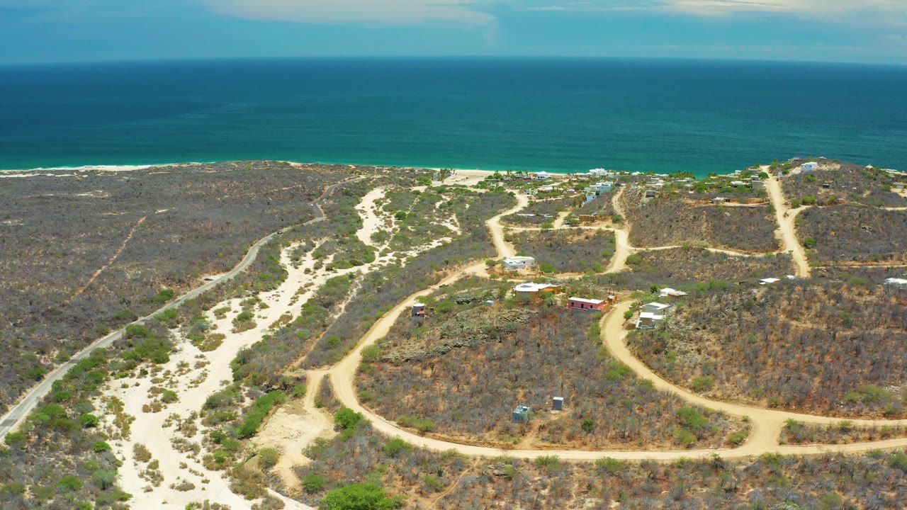 Wide aerial view of paths through scrub beside the sea