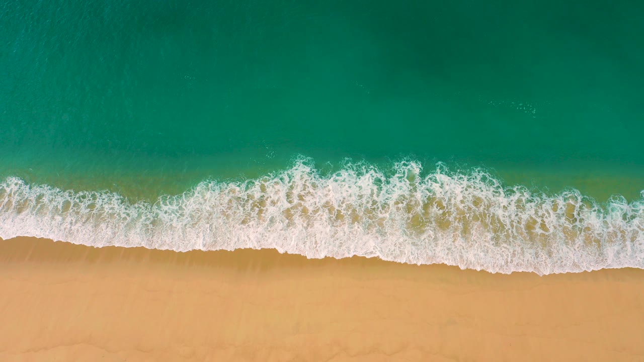 Overhead surf line meeting sandy beach