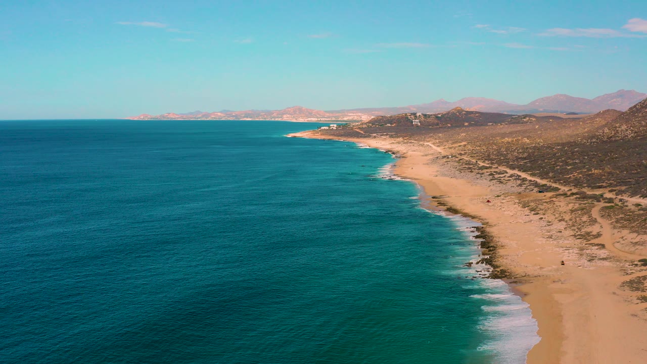 Aerial view of turquoise sea beside a long sandy coastline