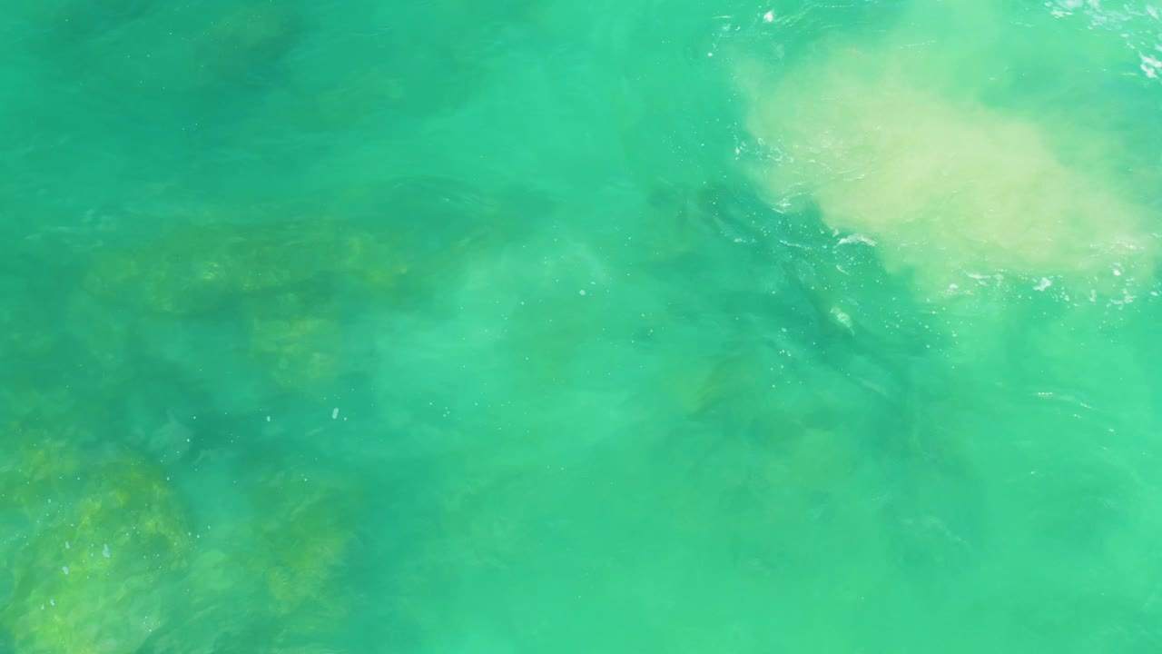Clear green-blue water with rocks under the surface.