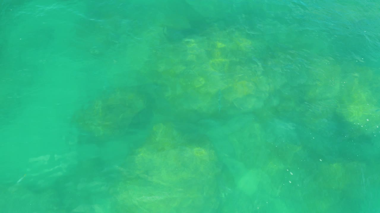Turquoise ocean water over submerged rocks