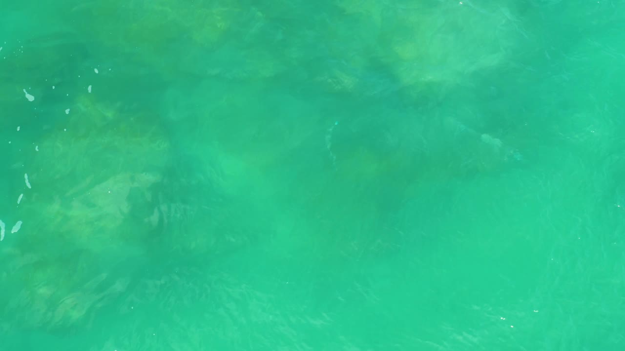 Clear green-blue water with faint rocks below.
