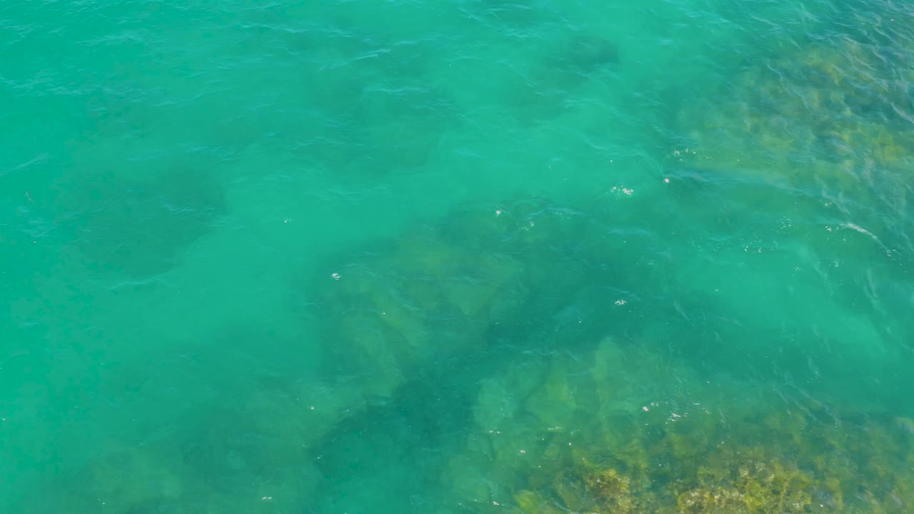 Blue-green water with rocks beneath the surface.