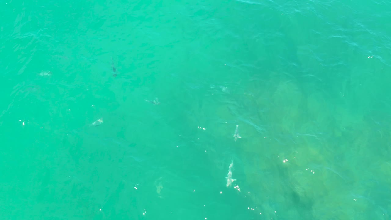 Clear shallow water at Laguna Beach, Baja California Sur, with diffuse submerged rocks visible through a slightly hazy turquoise surface, no visible people.